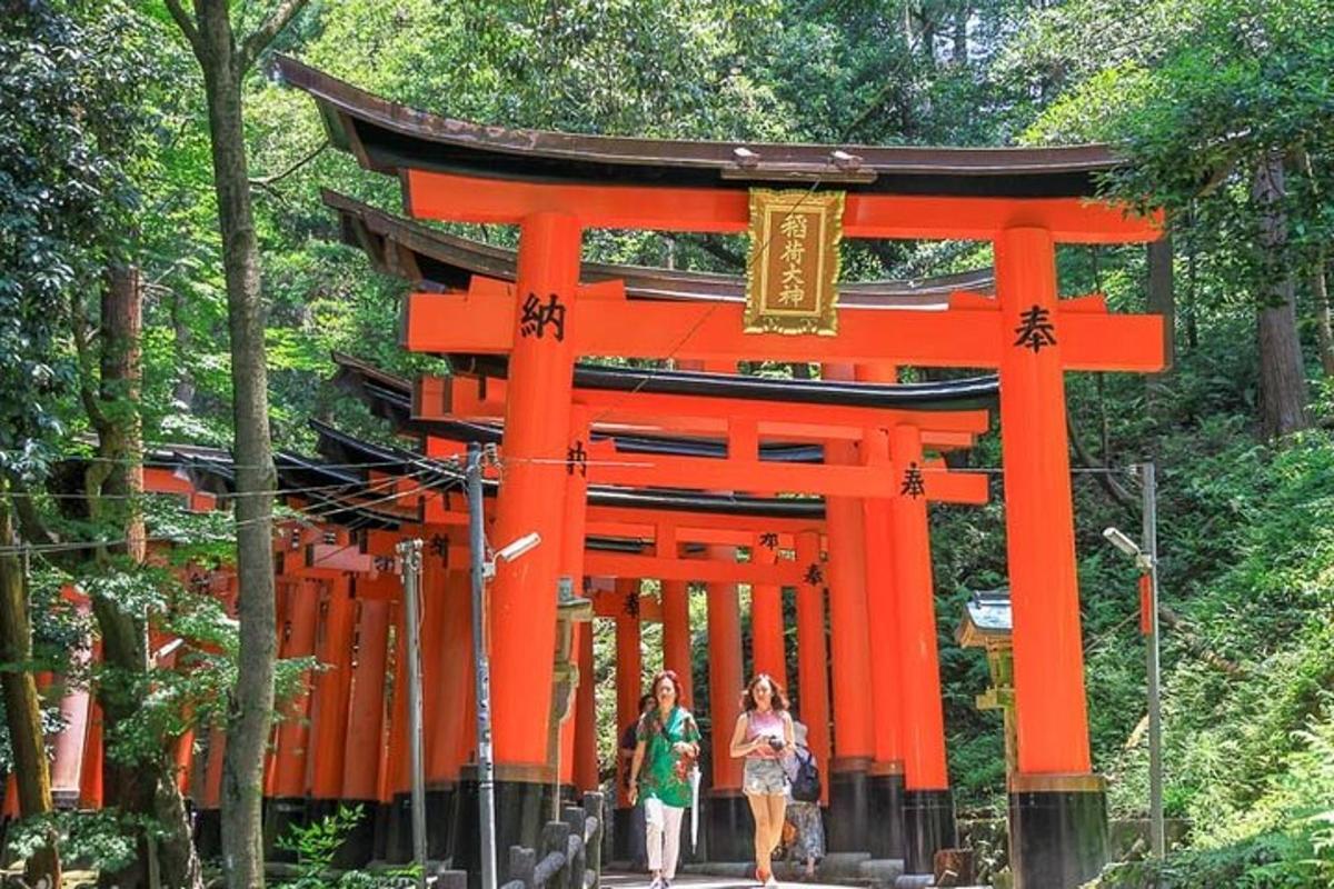 オレンジ色の鳥居の前を歩く人々