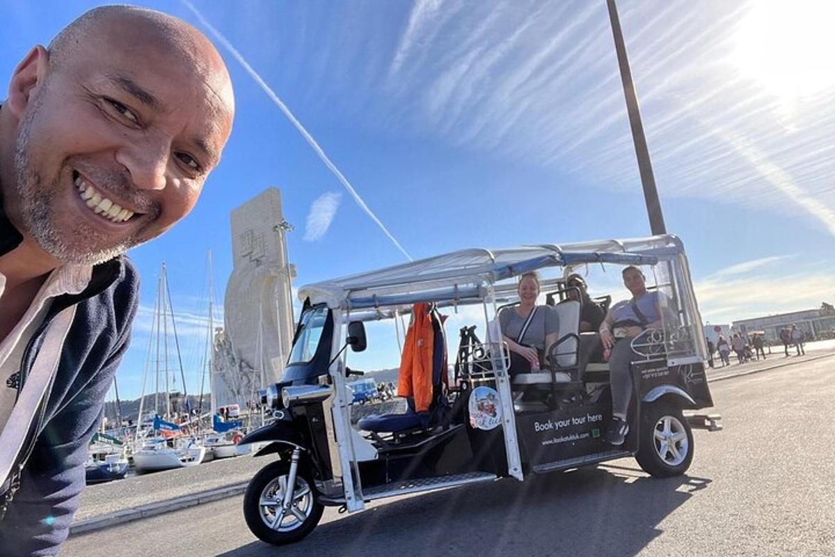 muž se usmívá vedle golfového vozíku
