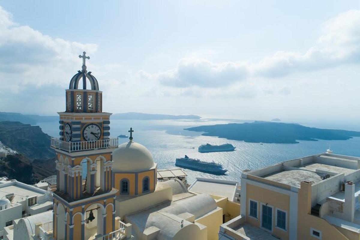 una torre dell'orologio in cima a un edificio vicino all'acqua