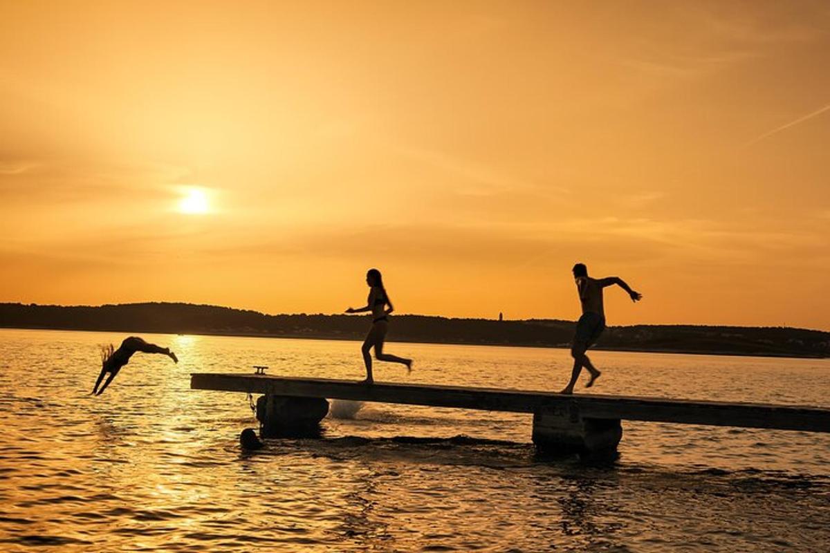 three people running on a dock in the water