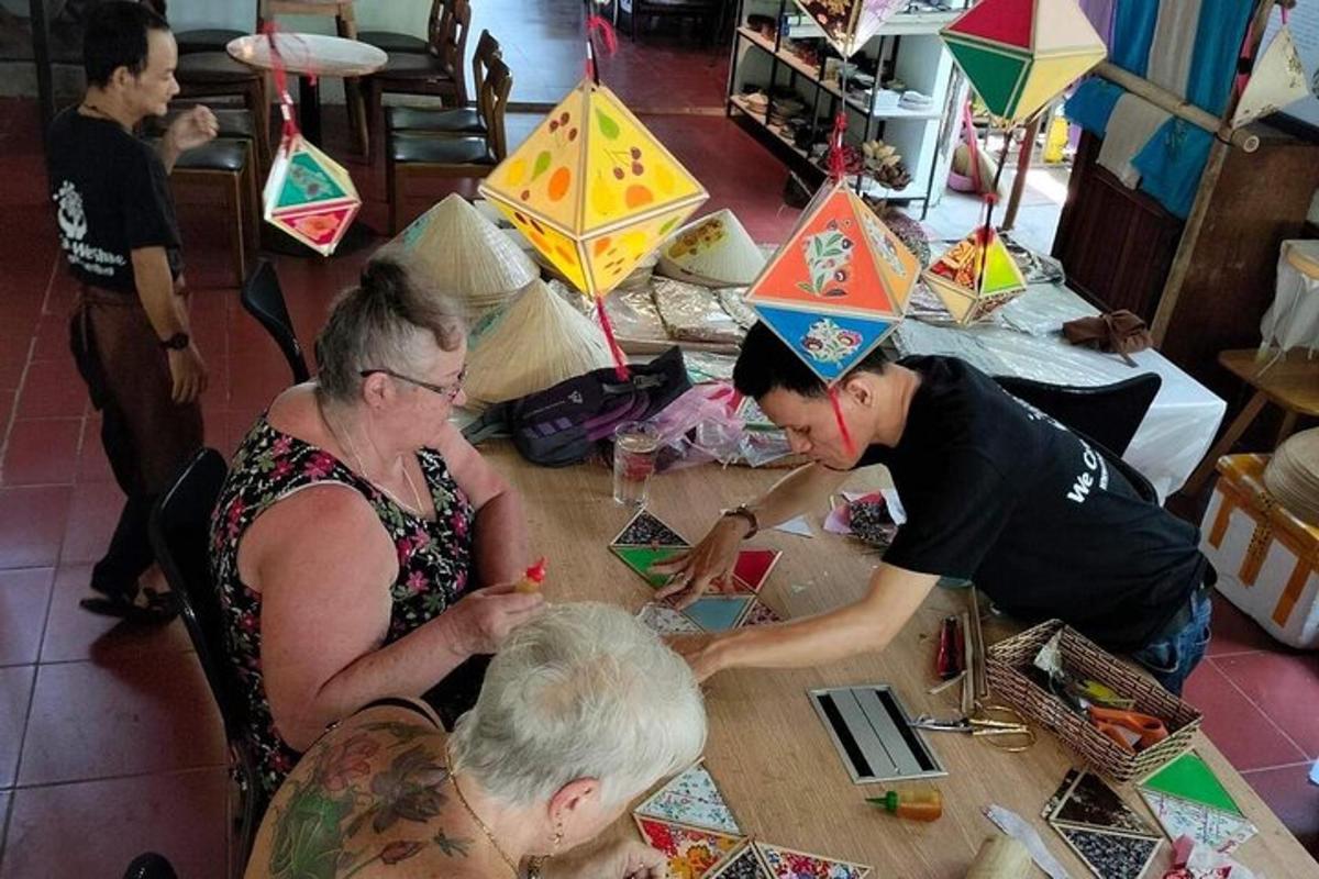 a group of people sitting at a table with kites