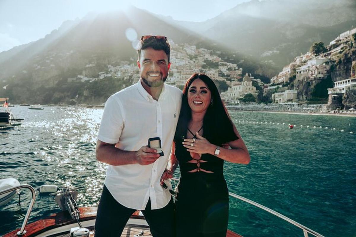a man and a woman standing on a boat