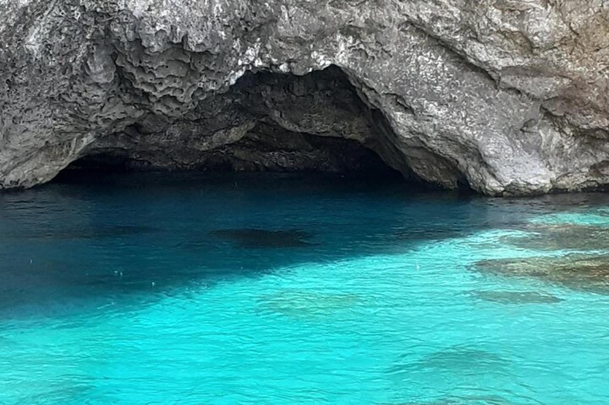 sebuah gua dengan air biru di hadapan tebing