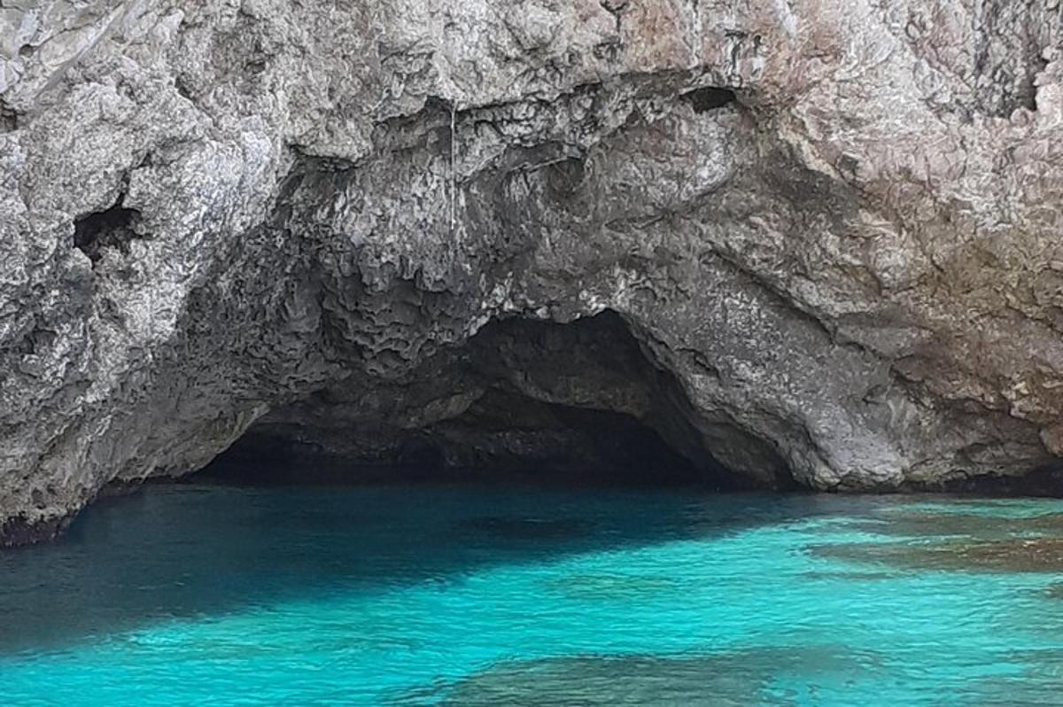 sebuah gua dengan air biru di hadapan tebing