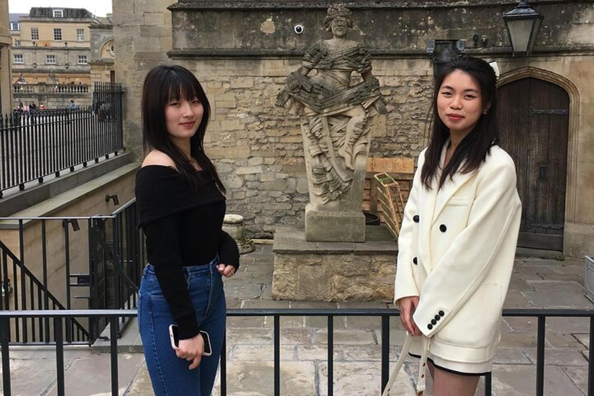 two young women standing in front of a building