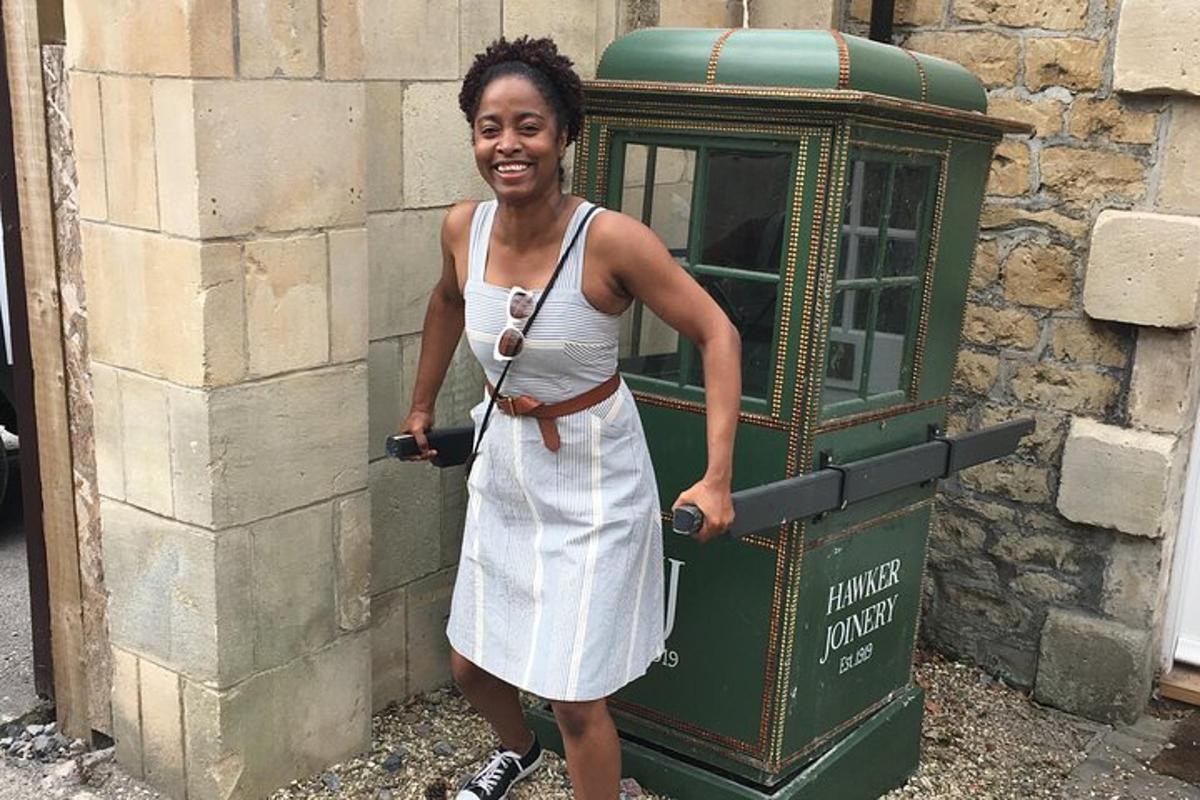 a woman in a white dress standing next to a phone booth