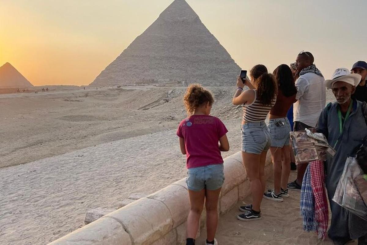 skupina lidí stojící před pyramidami