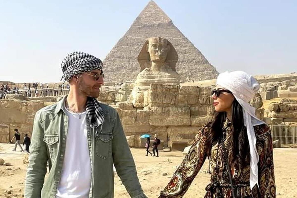 muž a žena stojící před pyramidami