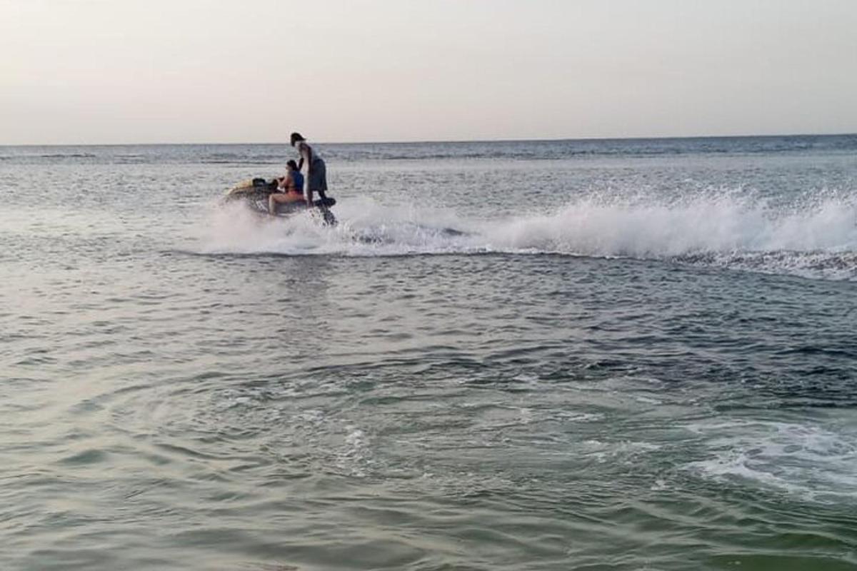 a couple of people riding a horse in the water