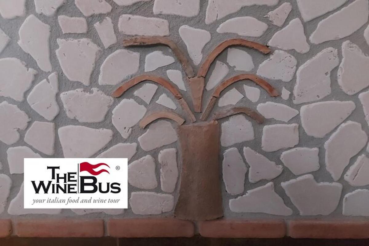 un cartello che dice "l'autobus del vino" accanto a un muro di pietra