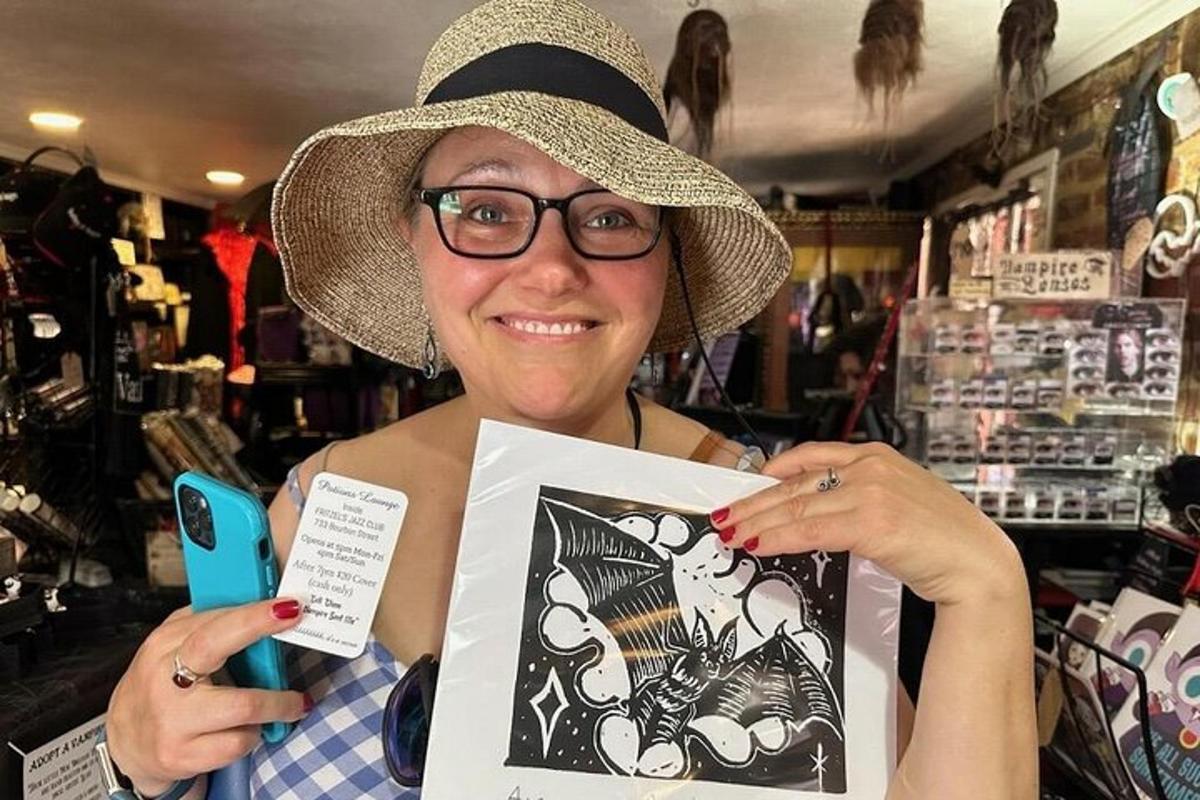a woman wearing a hat holding up a picture