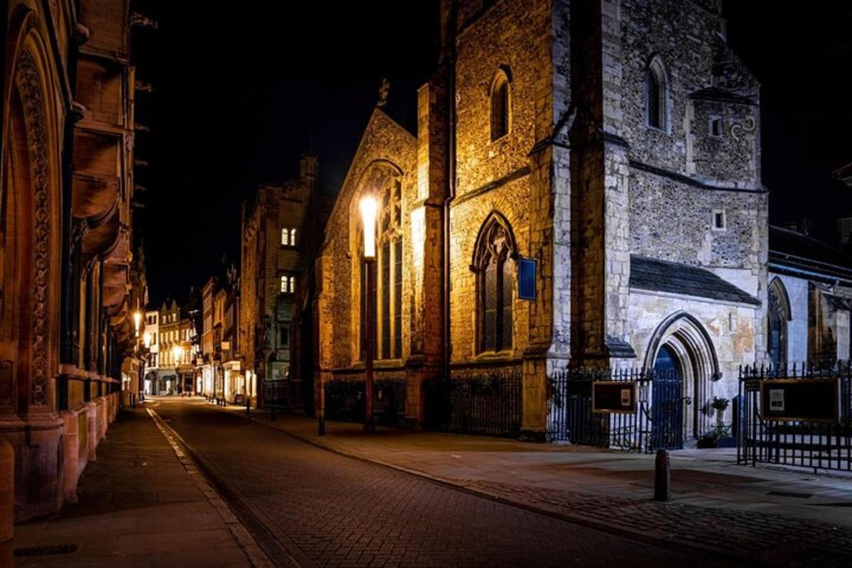 un vecchio edificio di notte con una strada di fronte