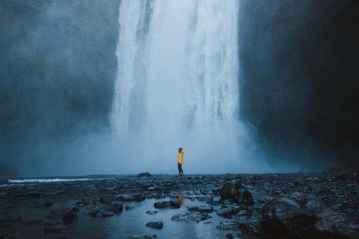 un uomo in piedi davanti a una cascata
