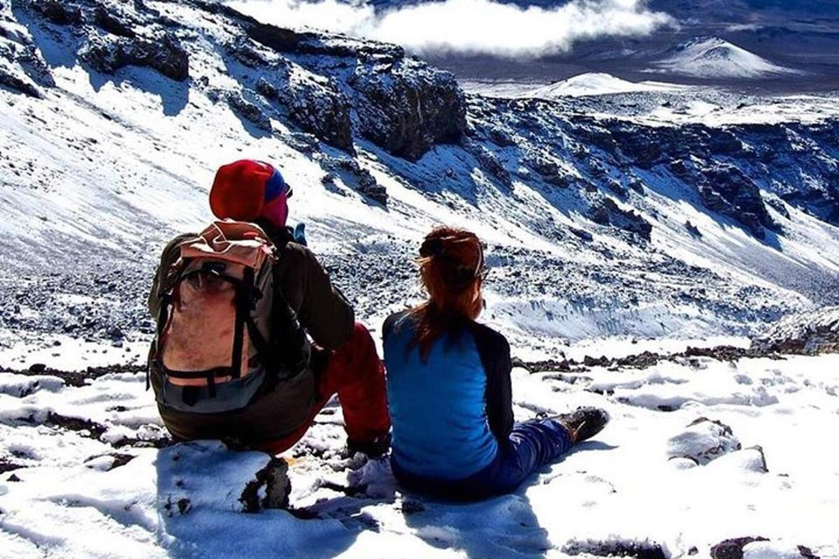 ein Mann und eine Frau sitzen auf einem schneebedeckten Berg
