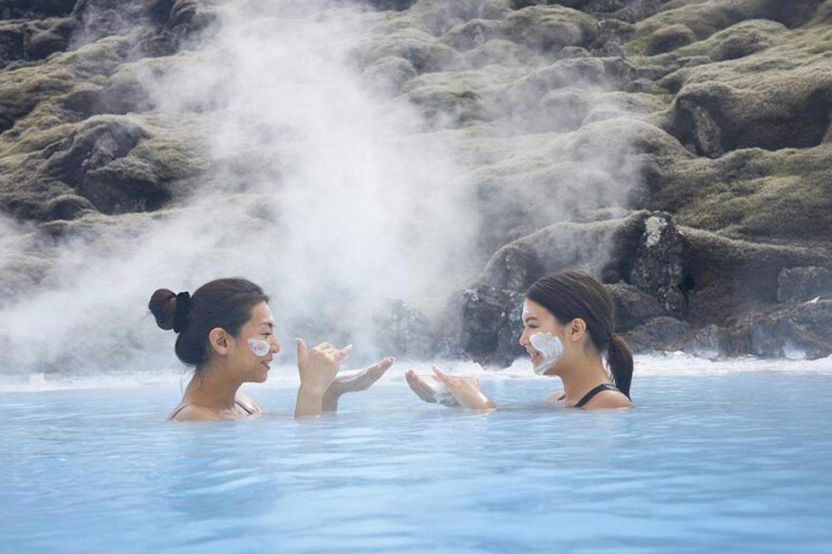 zwei Frauen schwimmen im Wasser eines Geysirs