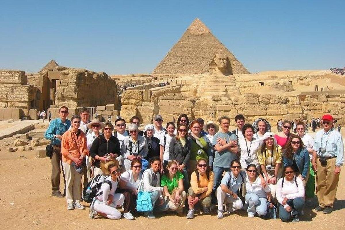 um grupo de pessoas posando em frente às pirâmides