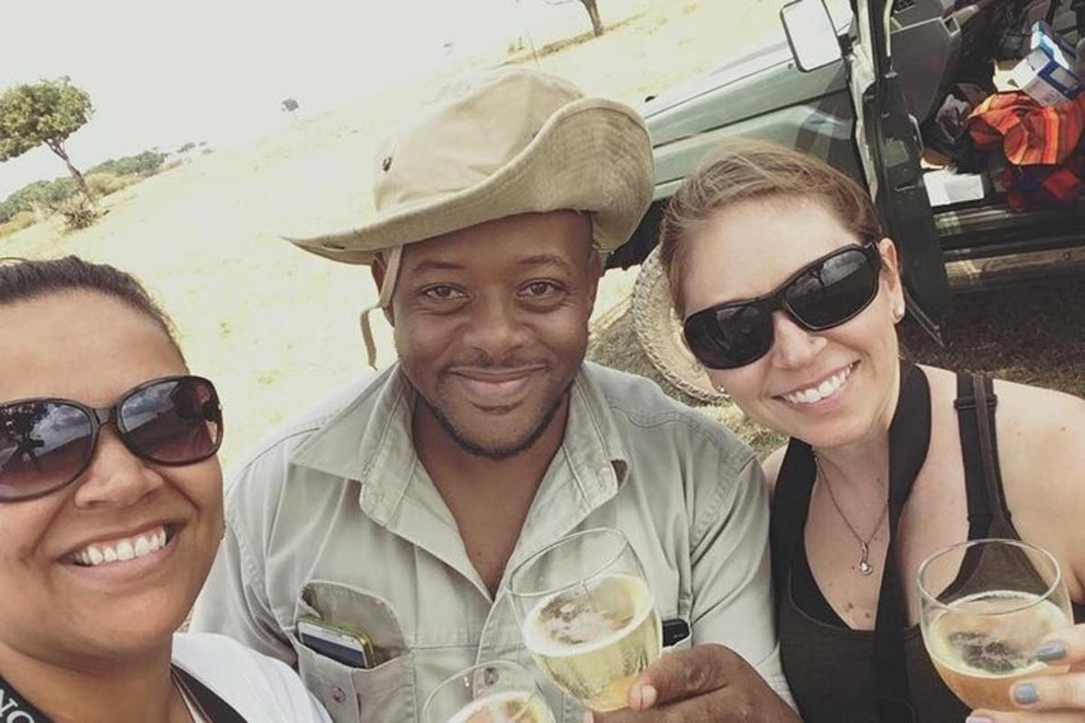 a group of three people posing for a picture with wine glasses