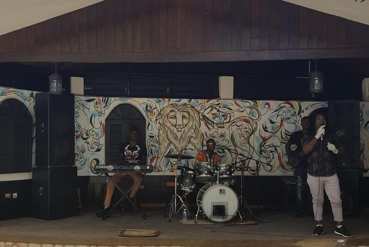 una band che suona su un palco davanti a un murale