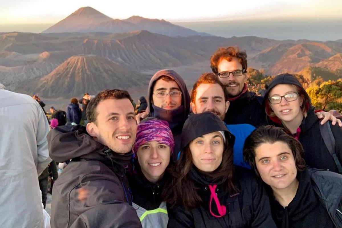 a group of people posing for a picture at the top of a mountain
