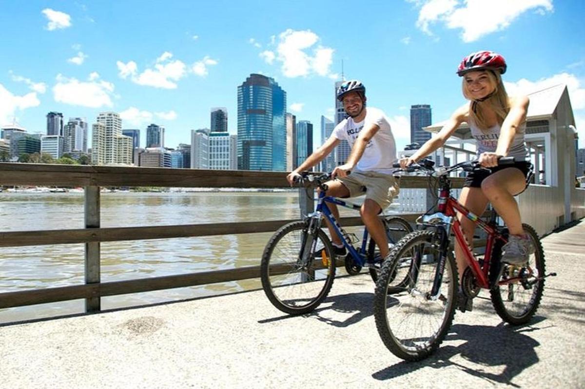 a man and a woman riding bikes on a bridge