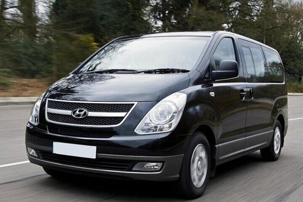 een zwarte bestelwagen rijdt over de weg