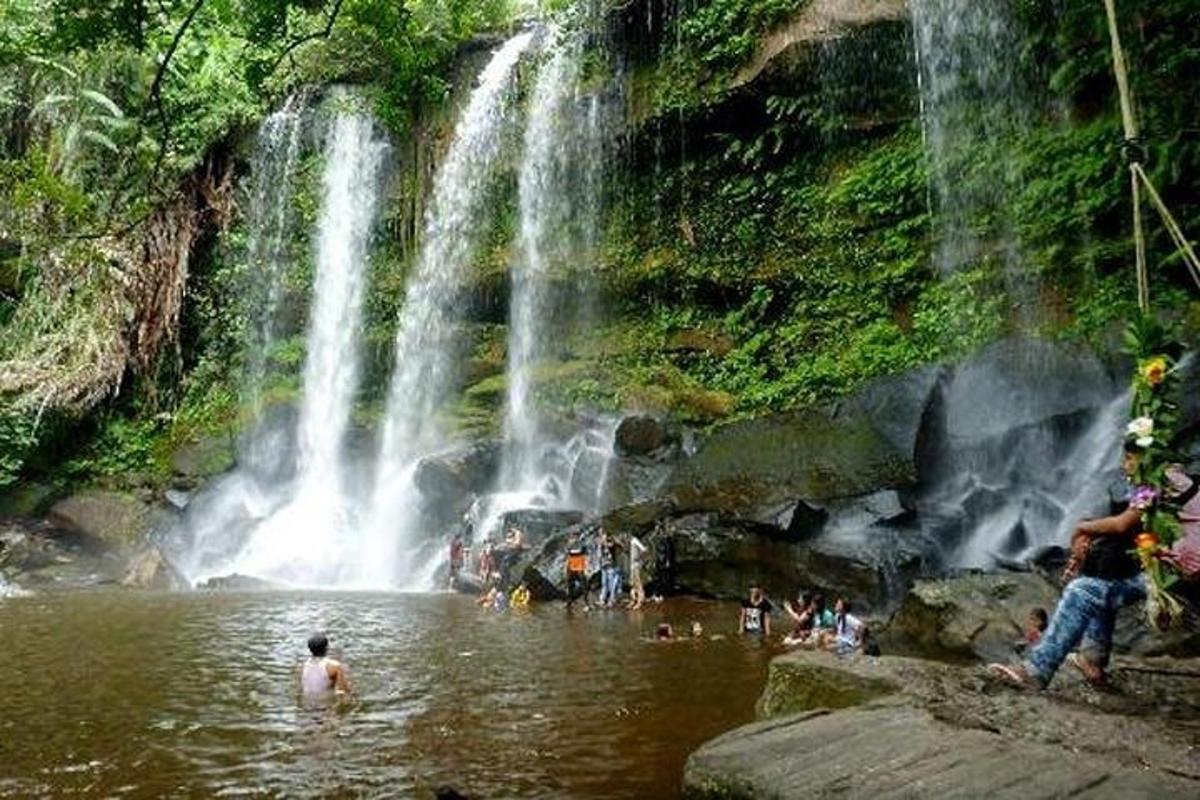 un gruppo di persone in acqua vicino a una cascata