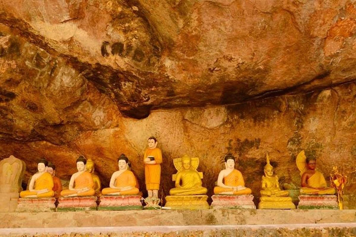 un gruppo di statue sedute davanti a una grotta