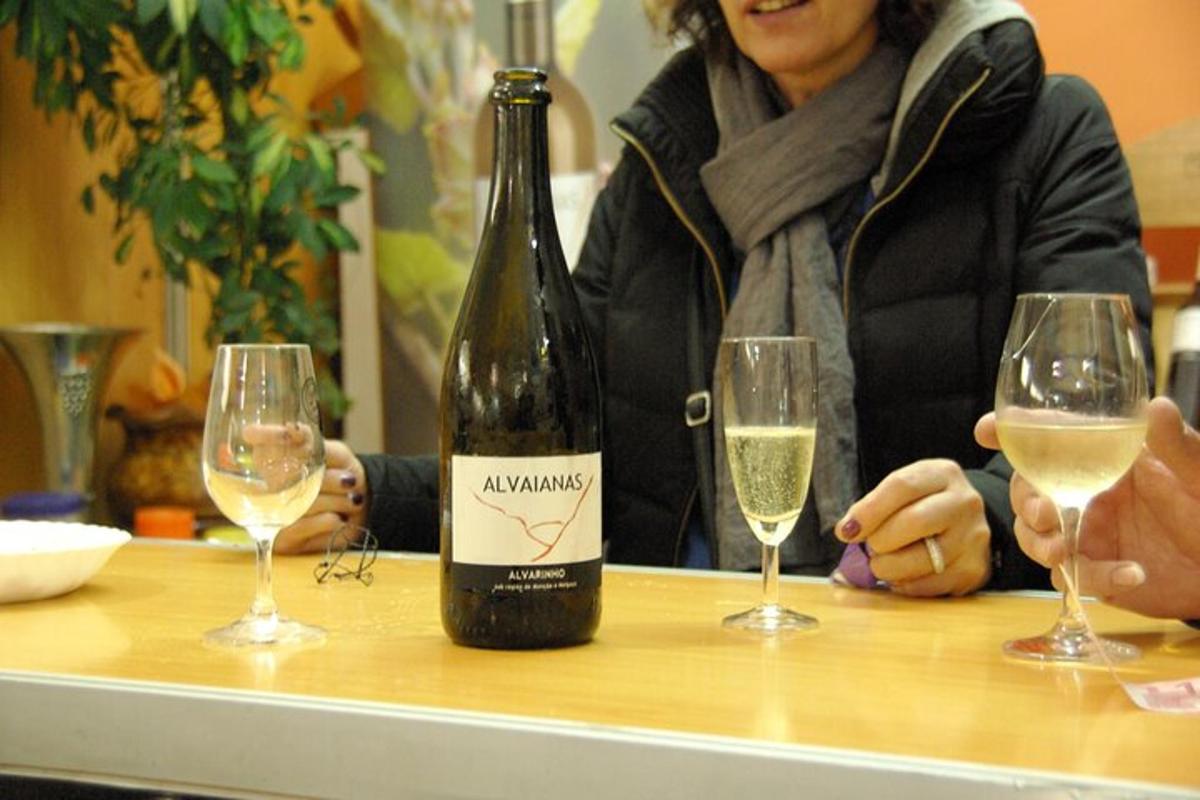 o femeie așezată la o masă cu două pahare de vin