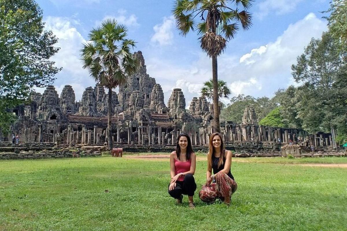 zwei Frauen sitzen auf dem Gras vor einem Tempel