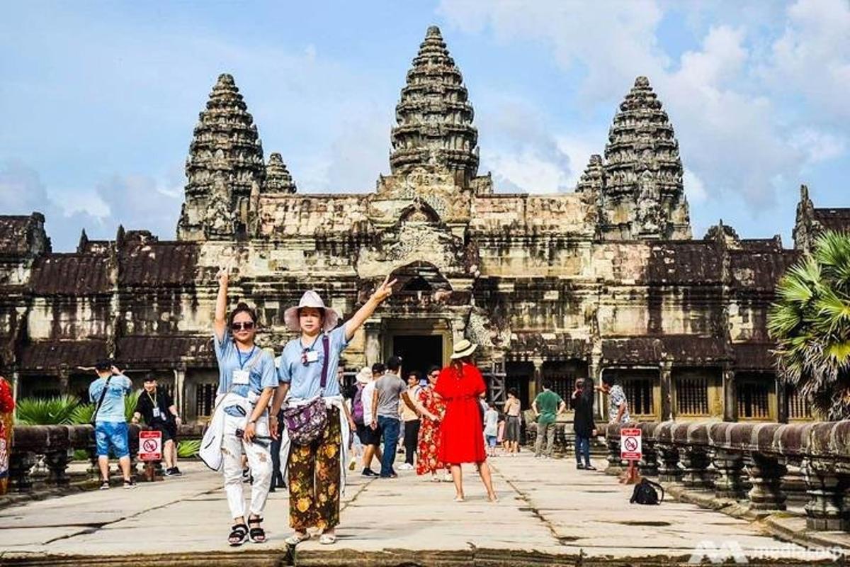un gruppo di persone che camminano davanti a un tempio