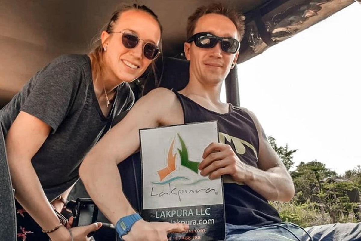 una dona asseguda al costat d'un home que sosté un cartell