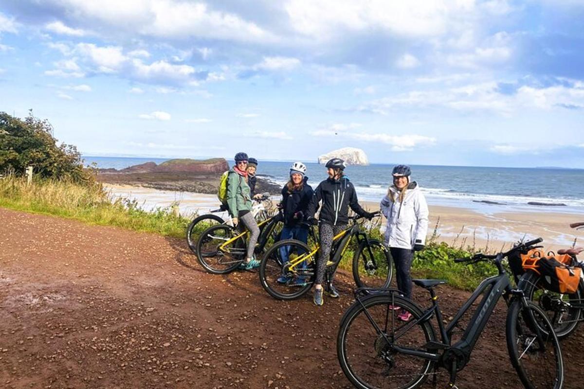a group of people standing next to their bikes on the beach