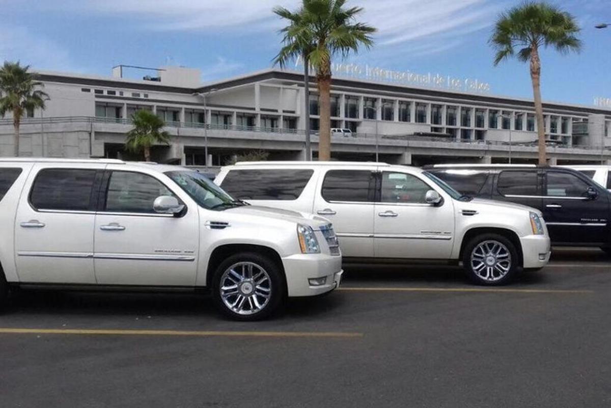 two white vehicles are parked in a parking lot