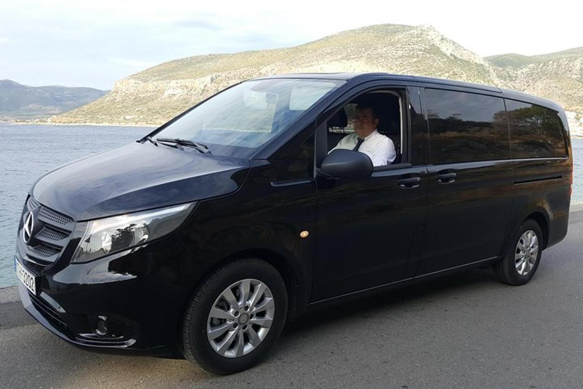 ένας άντρας που κάθεται στη θέση του οδηγού ενός μαύρου βαν