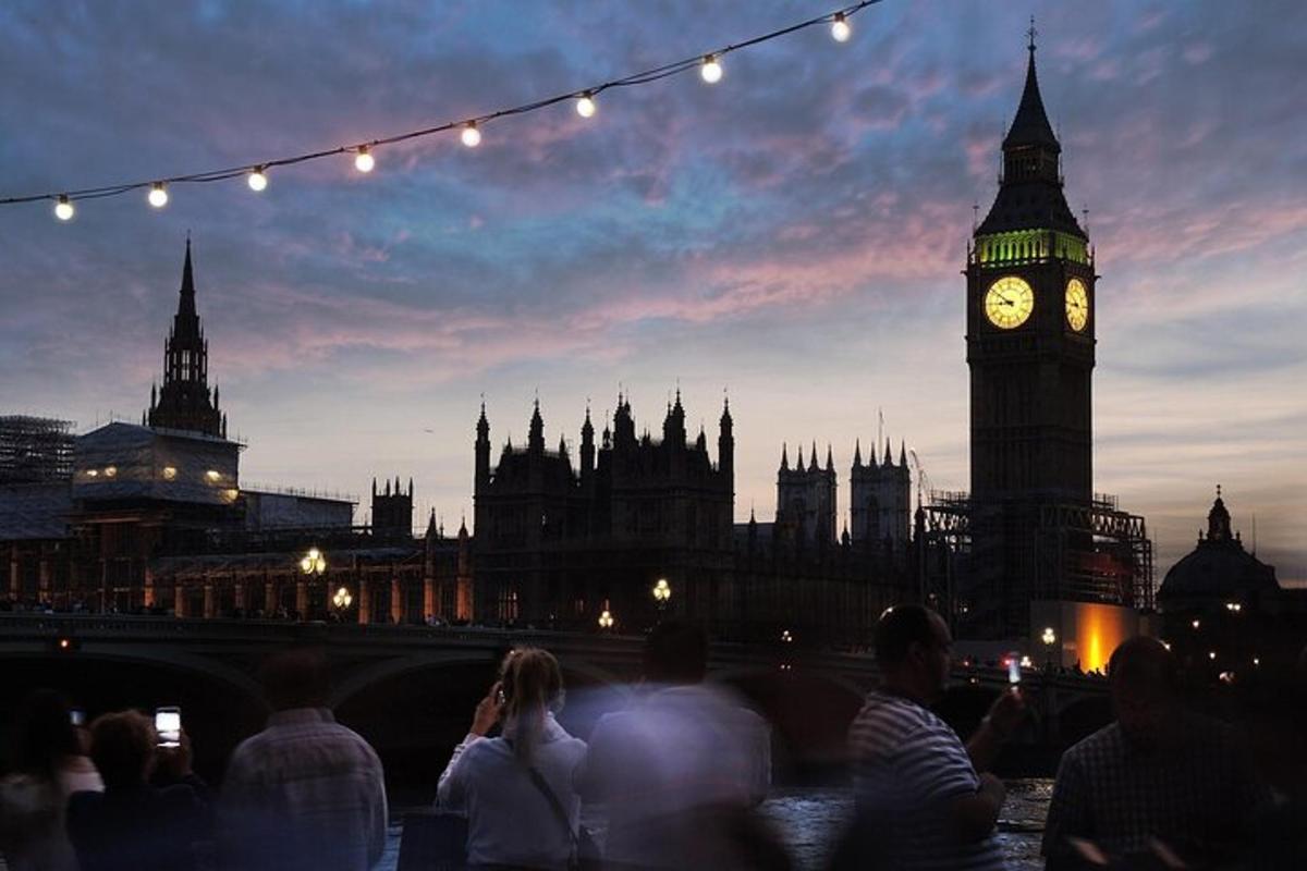 uma multidão de pessoas olhando para a torre do relógio do Big Ben