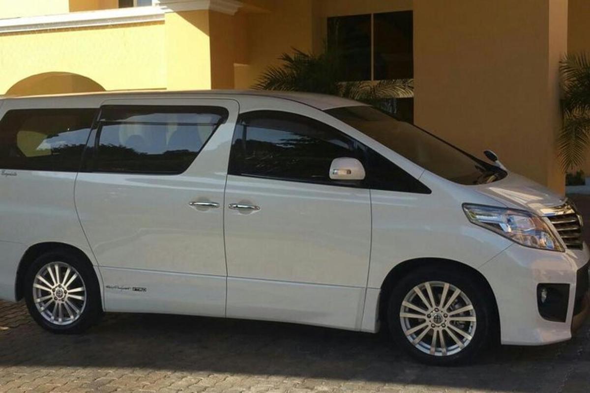 bílý minivan zaparkovaný před budovou