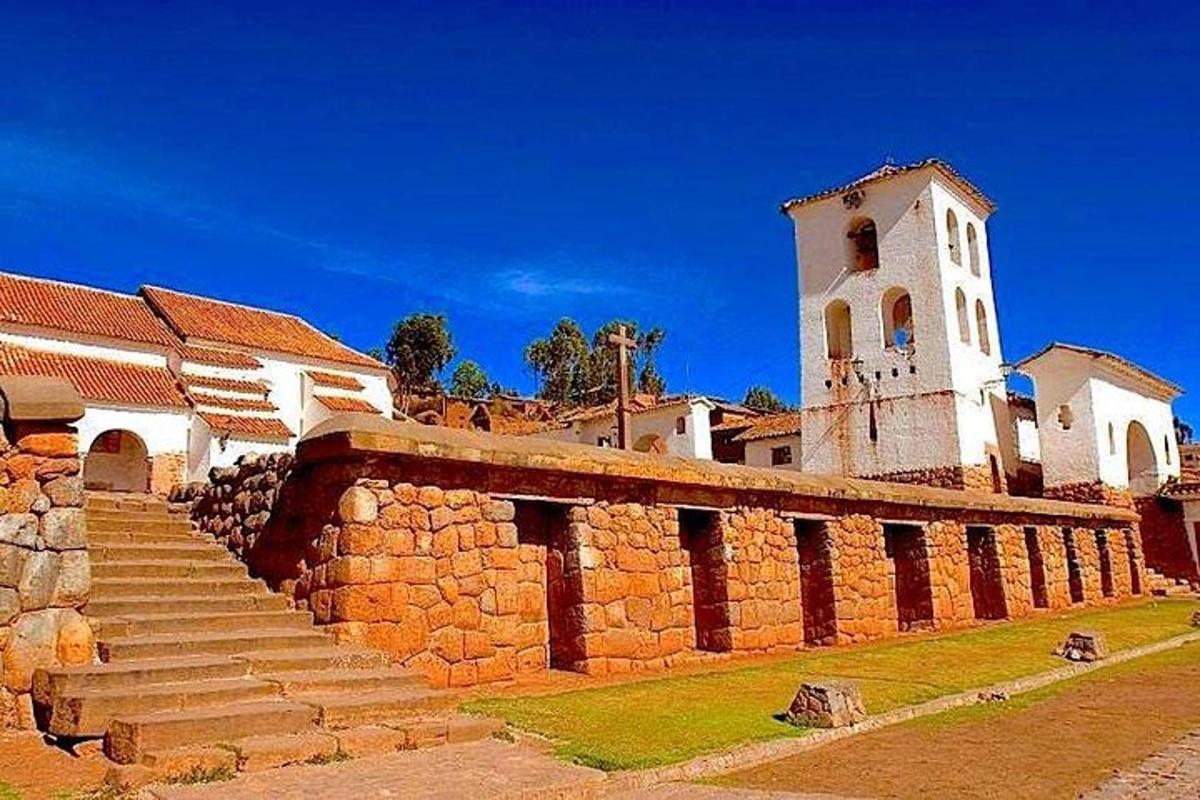 a church with a clock tower and a stone wall