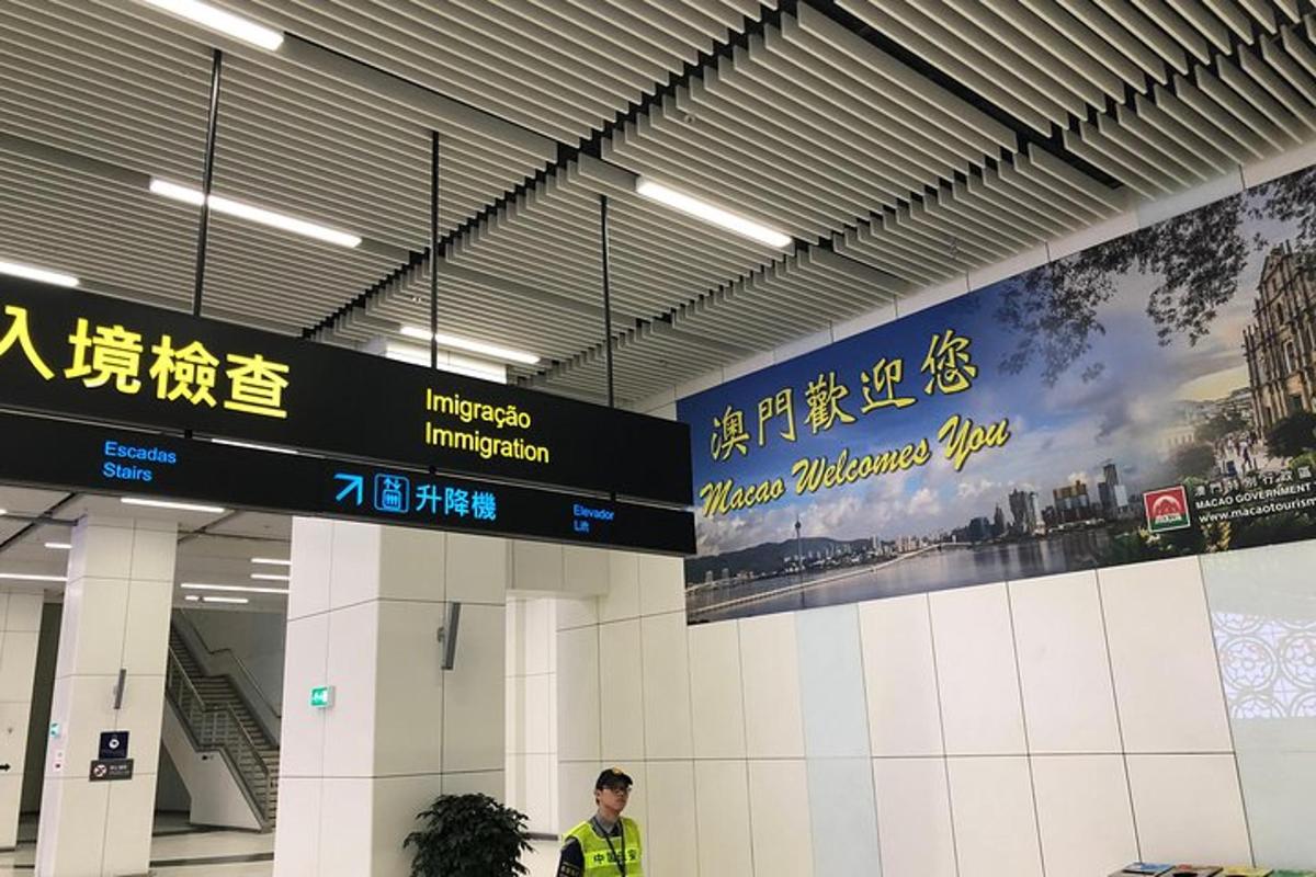 un uomo in piedi nel terminal di un aeroporto con dei cartelli