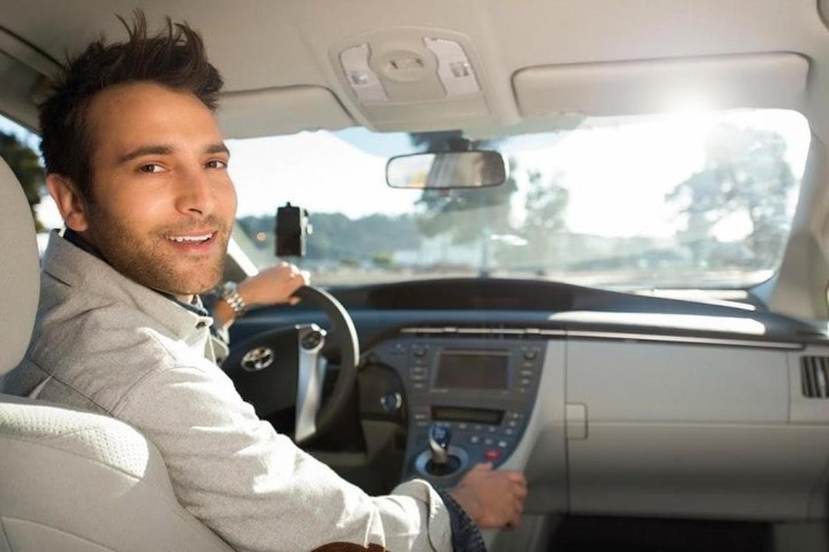 um homem sentado ao volante de um carro
