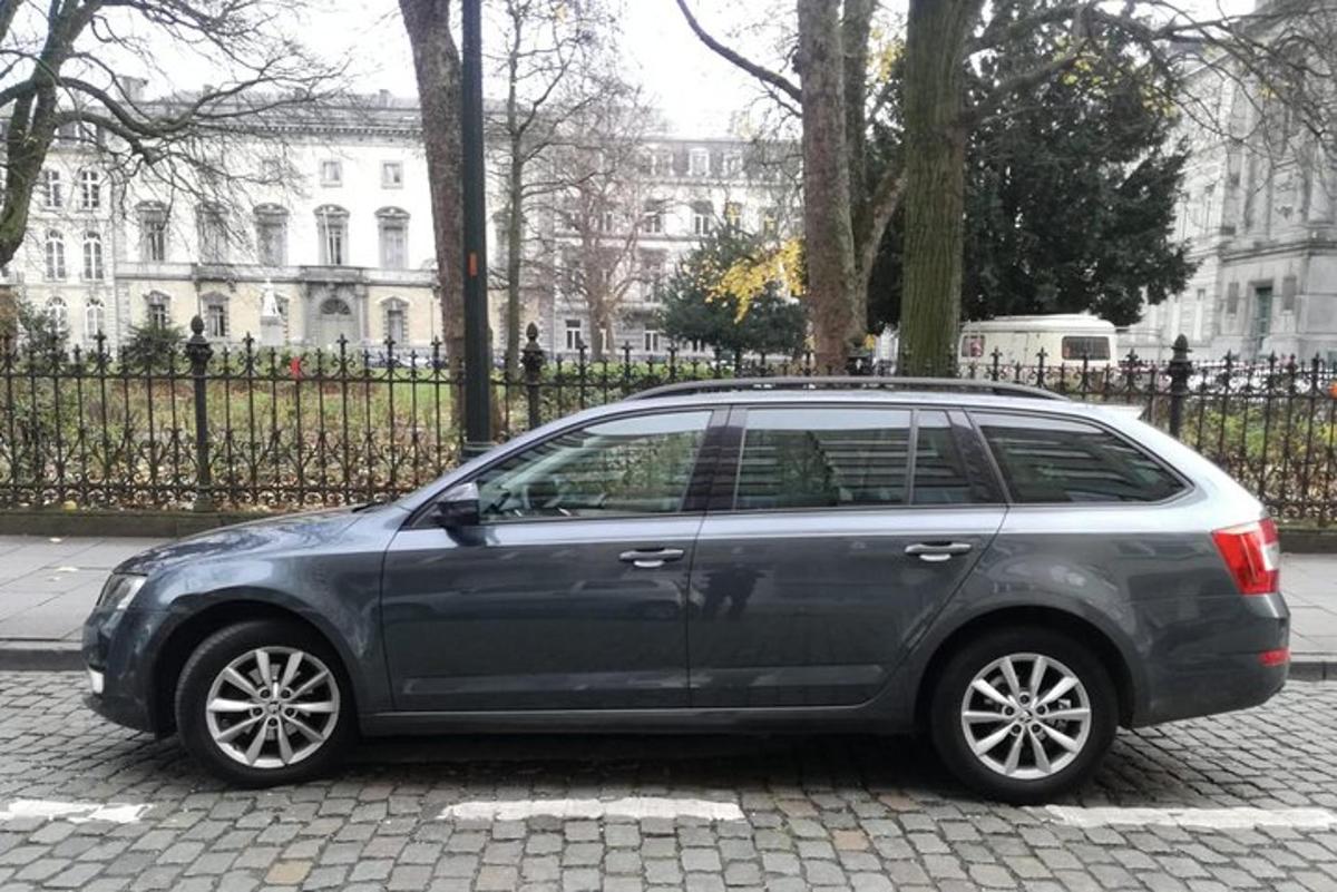 um carro cinza estacionado em frente a um prédio