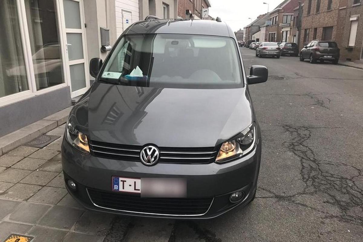 uma van branca estacionada na beira de uma rua