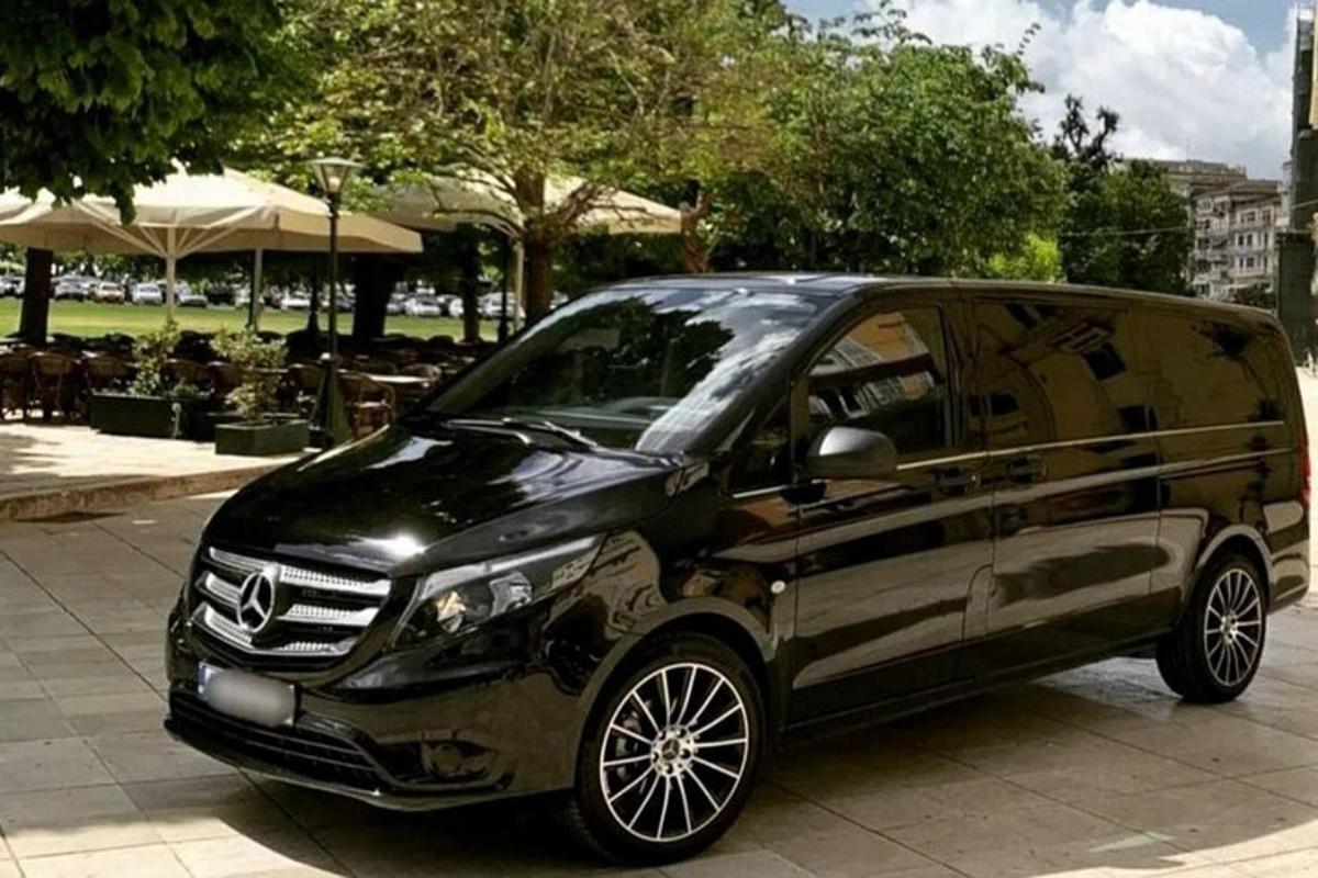 uma van preta está estacionada na calçada