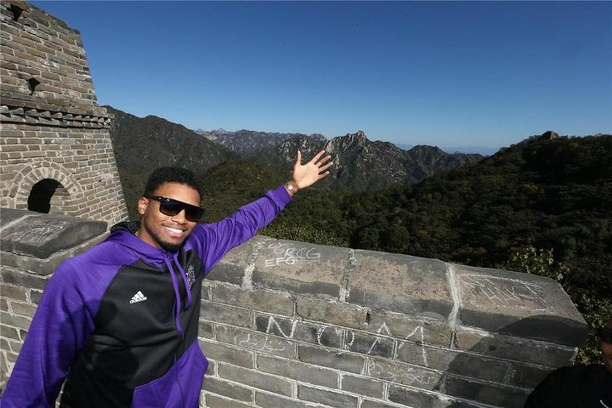 a man standing on a wall with his hand in the air