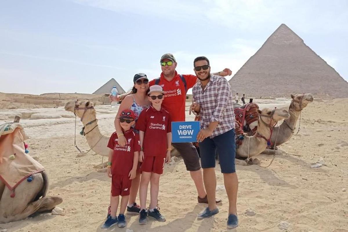a family holding up a sign in front of the pyramids