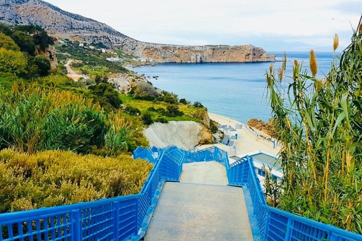 un escalier bleu menant à une plage avec l'océan