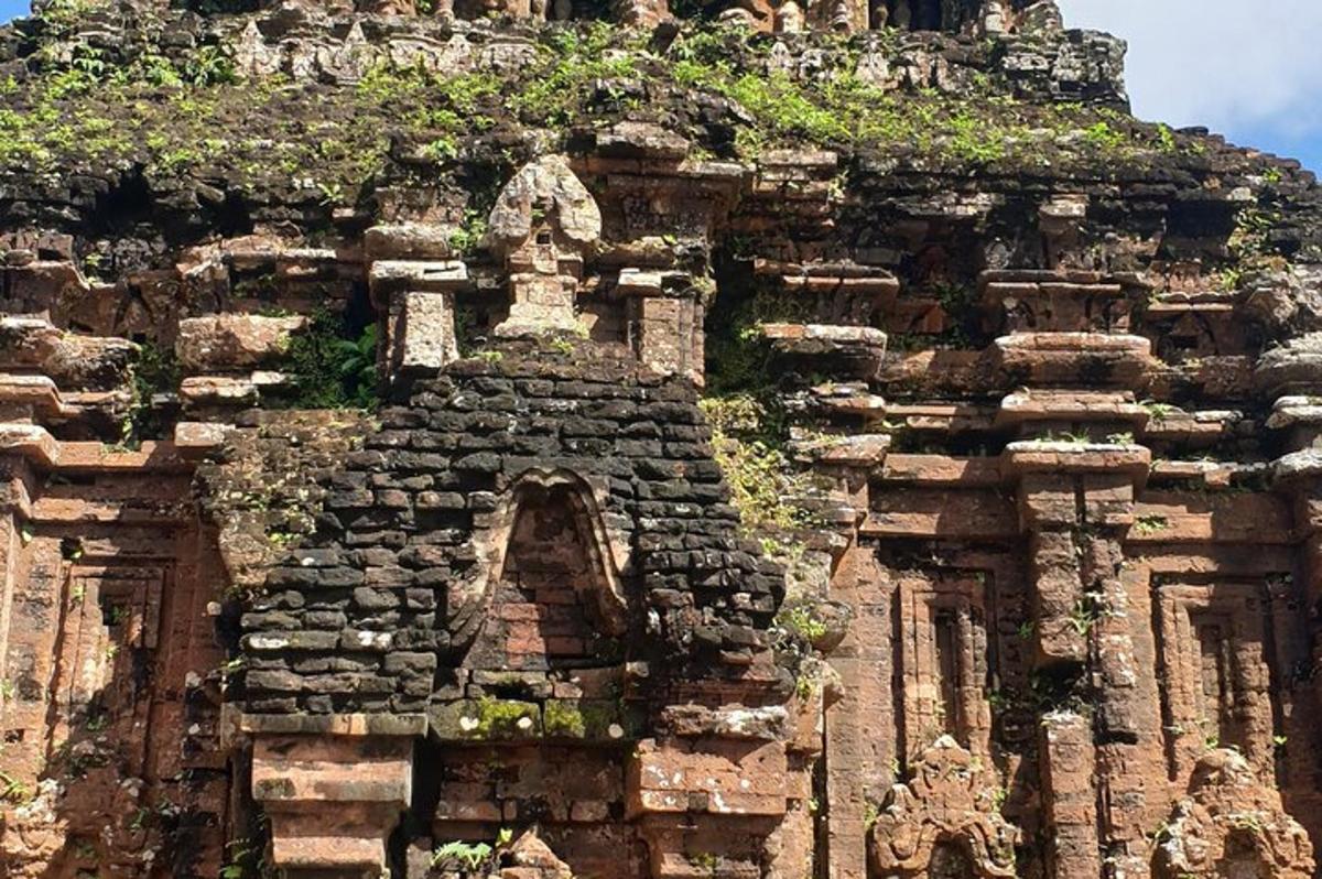 un edifici de pedra amb un turó amb vegetació