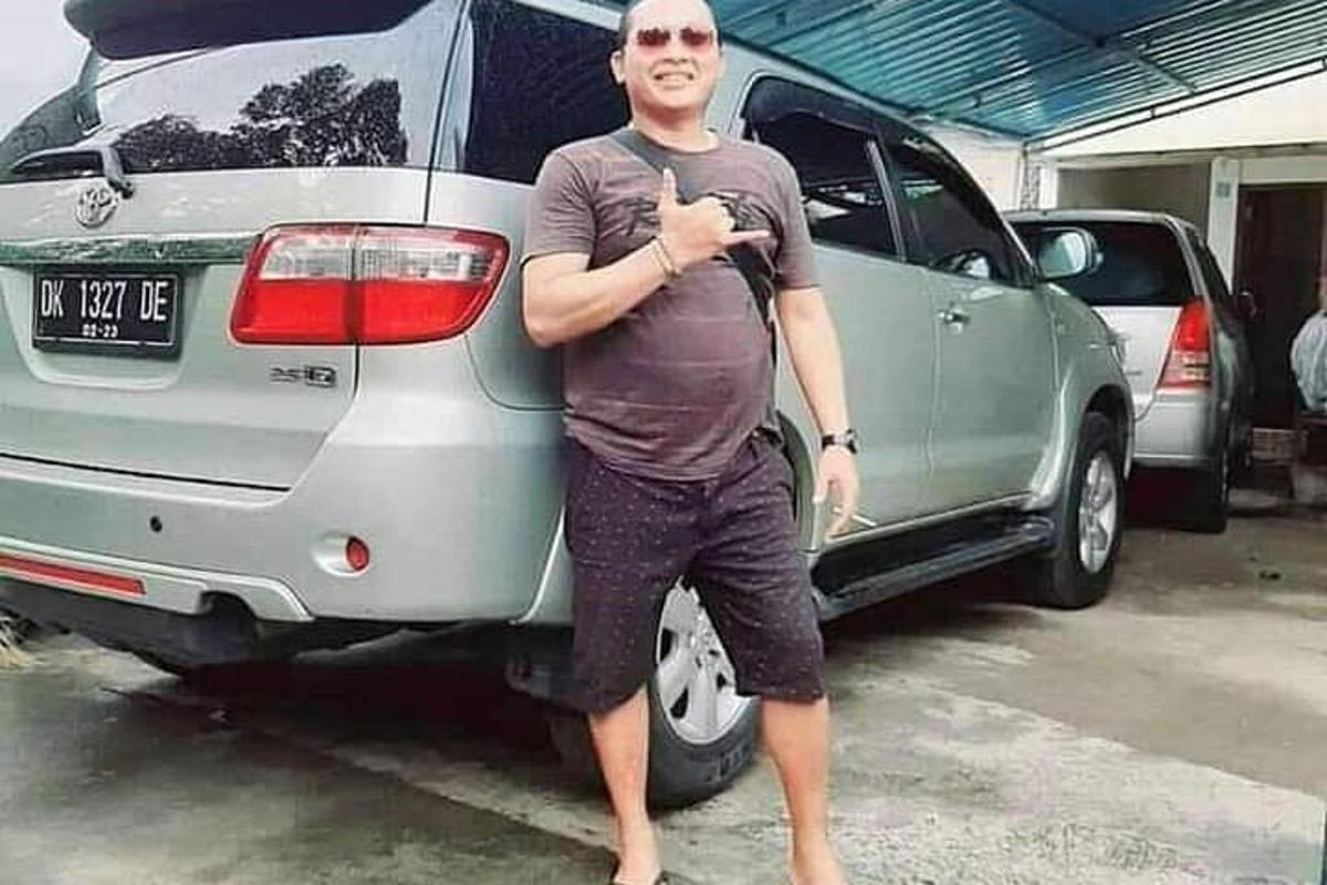 un hombre parado frente a un coche