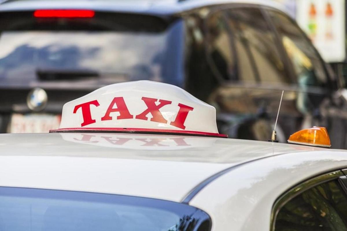 un cartello di taxi sopra un'auto bianca