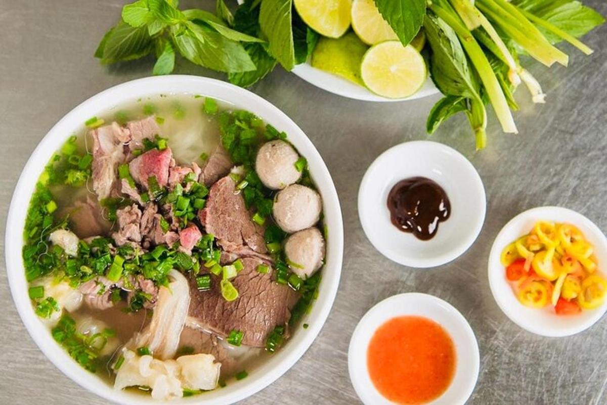 semangkuk sup dengan daging dan sayur-sayuran di atas meja