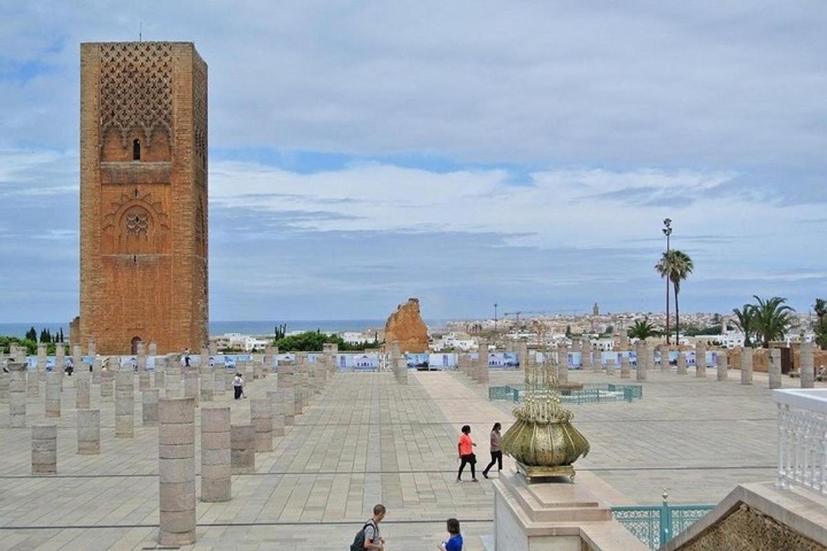 persone che camminano intorno a una piazza con una torre dell'orologio